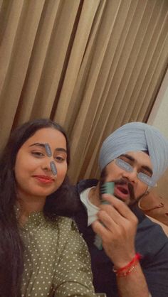 a man and woman are posing for the camera with their faces painted in different colors