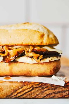 a sandwich with meat and cheese on a cutting board