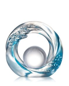 an artistic glass sculpture is displayed on a white surface with reflection in the center and blue swirls around it