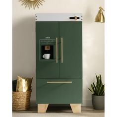 a green refrigerator freezer sitting next to a potted plant