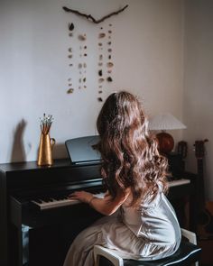 a woman sitting at a piano playing it