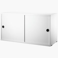 a white cabinet with two black knobs on the doors