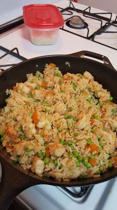 a pan filled with rice and vegetables on top of a stove