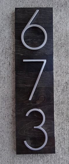 a wooden sign with the number three on it's side and two numbers below