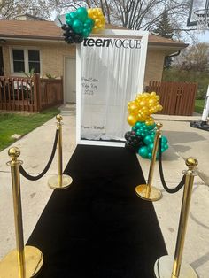 a black carpet with gold poles and balloons on it, along with a sign that says lenovoue