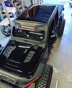 the jeep is parked in the garage with its hood up