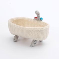 a knitted toy bathtub with an elephant on it's back and feet