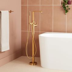 a bathtub with a gold faucet next to a white tub in a bathroom