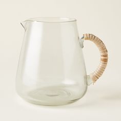 a clear glass pitcher with a wooden handle