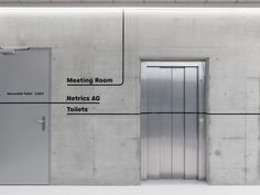 two metal doors are shown in front of a concrete wall with the words meeting room, necics ac toilets