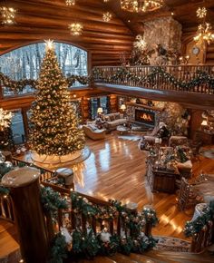 a christmas tree is in the middle of a large room with wooden floors and stairs