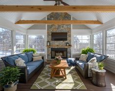 a living room filled with furniture and a fire place in the middle of an open floor plan