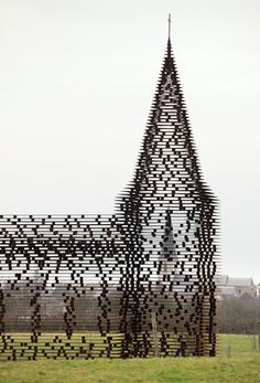 a large building made out of sticks in the middle of a field