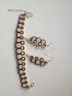 a necklace and earring set made out of polymer beads with black, white and gold swirls