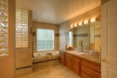 a large bathroom with two sinks and a bathtub next to a walk in shower