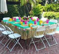 a table set up for a party next to a pool