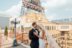 a bride and groom pose for a photo in front of the fremont theatre sign on their wedding day