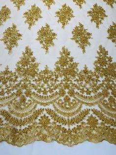 gold sequins on white sheer fabric with golden flowers and leaves in the center