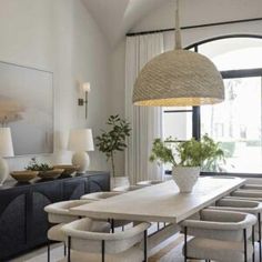 the dining room table is surrounded by white chairs