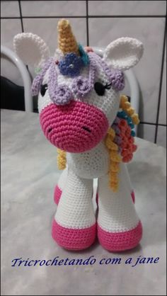 a crocheted stuffed unicorn is sitting on the table