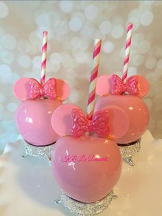 three pink minnie mouse cupcakes with candy sticks