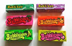 four bars of bubblelicious are lined up on a white surface, each with different flavors