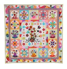 a colorful quilt with flowers and birds on it's center piece is displayed in front of a white background