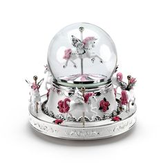 a snow globe with pink flowers and unicorns on it's sides, in front of a white background