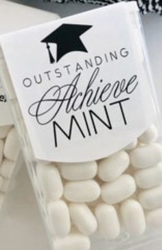 small white marshmallows in a plastic container with a black and white graduation cap on top