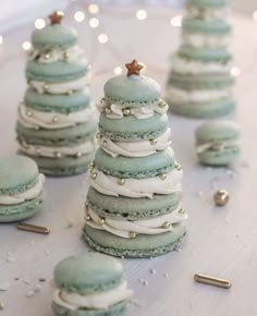 green macaroons with white frosting and gold sprinkles on a table