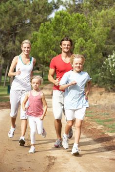 a family running down a dirt road with trees in the background