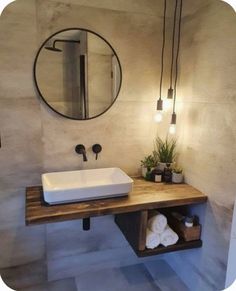 a bathroom with a sink, mirror and plant on the counter in front of it