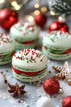 several decorated cookies sitting on top of a table next to christmas decorations and baubles