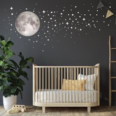 a baby's room with stars and moon wall decals on the walls, along with a crib