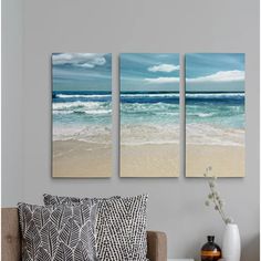 three canvases hanging on the wall above a couch in front of a coffee table