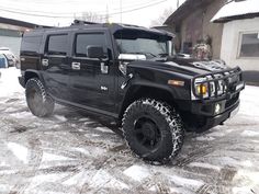 a black hummer is parked in the snow