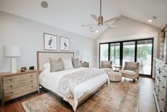 a large bed sitting in a bedroom next to a dresser and chair on top of a hard wood floor