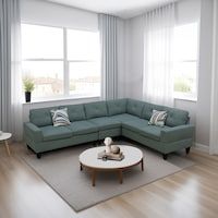 a living room with a sectional couch and coffee table in front of two large windows