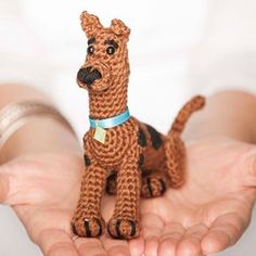 a person holding a small toy dog in their hands