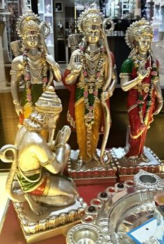 three statues of hindu deities on display in a store