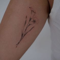 a woman's arm with a flower tattoo on the left side of her arm