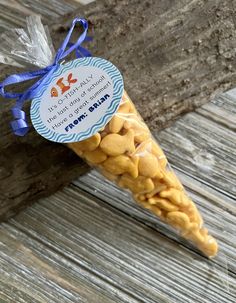 a stick with some kind of candy in it sitting on a wooden table next to a blue ribbon