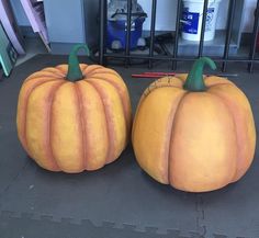 two giant pumpkins sitting next to each other