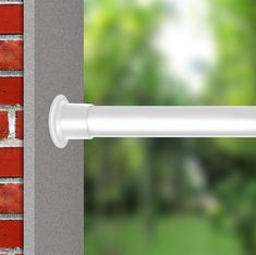 an open window with a brick wall and green trees in the background