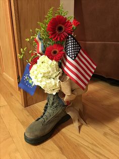 a boot with flowers and american flags on the floor in front of a wooden door