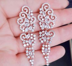 A beautiful pair of bridal earrings that is sure to make a bold statement on your Wedding Day! Adorned with glowing cubic zirconia that capture the light from every angle with a perfectly translucent appeal, the earrings are rhodium/rose gold plated for a bright finish which enhances the intricate detailing and conveys a modern take on old elegance. Length of the earring is 2.4" (approx. 6.1cm); Width: 0.7" (approx. 1.8cm); Weight: 12g. Available in Silver and Rose Gold finishes. To make your ch Glamorous Rose Gold Cubic Zirconia Chandelier Earrings, Rose Gold Cubic Zirconia Bridal Earrings For Wedding, Dazzling Rose Gold Cubic Zirconia Bridal Earrings, Glamorous Rose Gold Cubic Zirconia Bridal Earrings, Dazzling Rose Gold Bridal Earrings, Rose Gold Cubic Zirconia Diamond Earrings For Wedding, Rose Gold Bridal Earrings With Sparkling Cubic Zirconia, Glamorous Rose Gold Cubic Zirconia Crystal Earrings, Rose Gold Elegant Diamond Earrings For Wedding