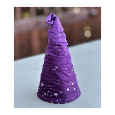 a purple hat with stars on it sitting on top of a white tablecloth covered surface