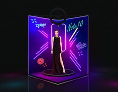 a woman is standing in front of a display with neon lights on the wall and behind her she is wearing a black dress