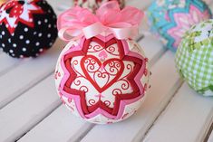 three decorative ornaments sitting on top of a white wooden table with polka dots and bows