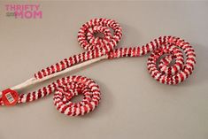 a pair of red and white candy canes tied to a hook on a table